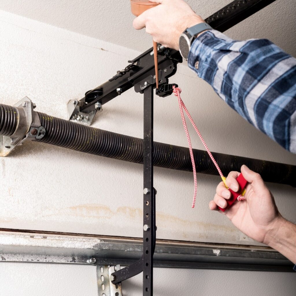 experienced technician from Star City Garage Doors works on garage door spring replacement